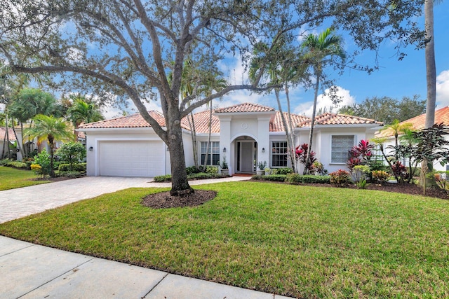 mediterranean / spanish house with a garage and a front yard