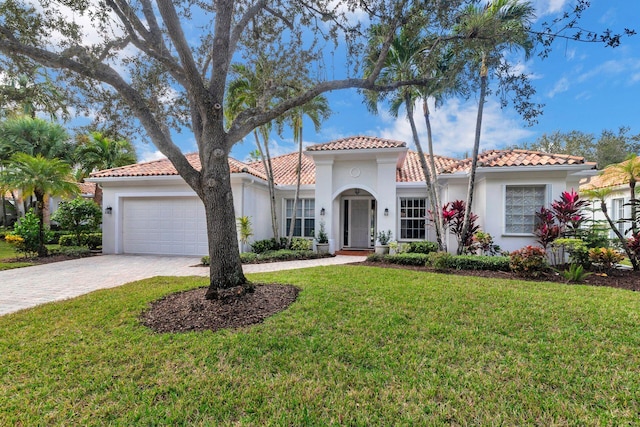 mediterranean / spanish house with a front yard and a garage