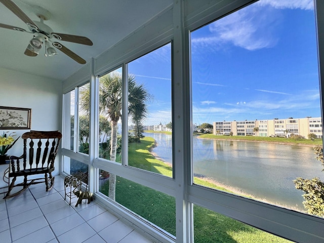 unfurnished sunroom with ceiling fan and a water view