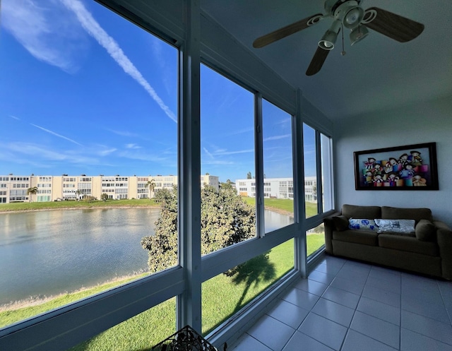 unfurnished sunroom featuring a water view and ceiling fan