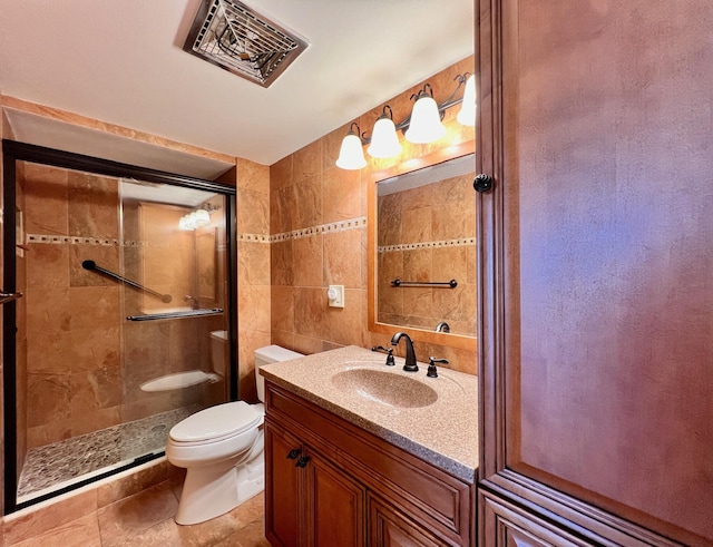 bathroom featuring walk in shower, vanity, tile walls, and toilet