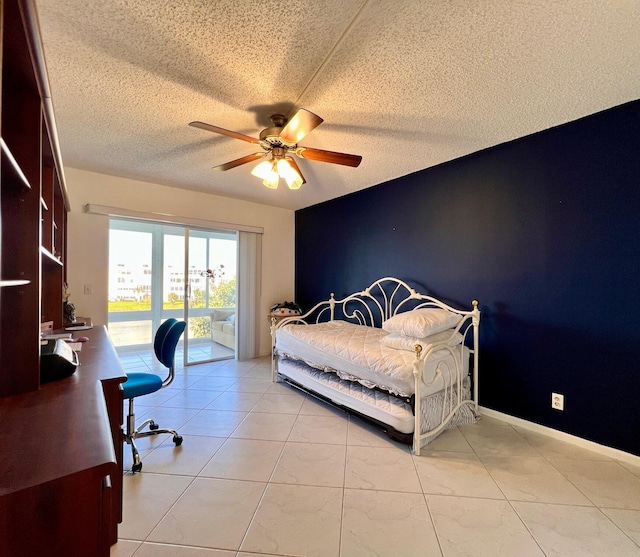 tiled bedroom with ceiling fan, access to exterior, and a textured ceiling