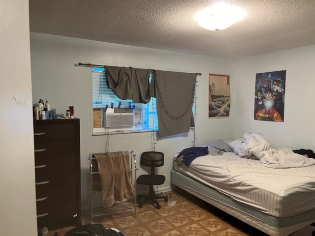 bedroom featuring a textured ceiling and cooling unit