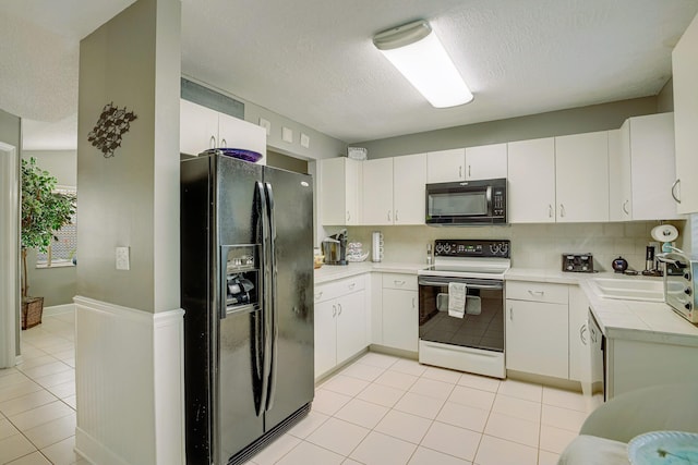 kitchen with white cabinets, backsplash, sink, and black appliances