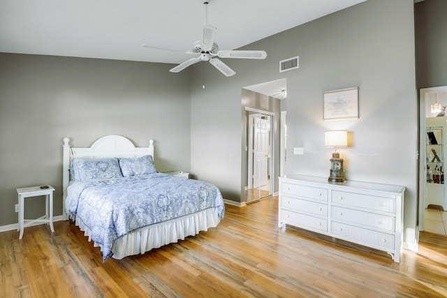 bedroom featuring ceiling fan, light hardwood / wood-style flooring, and high vaulted ceiling