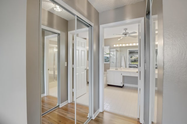 hallway featuring a textured ceiling and light hardwood / wood-style floors