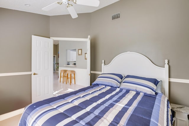 bedroom with a textured ceiling, tile patterned floors, and ceiling fan