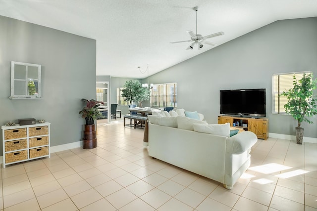 living room featuring light tile patterned floors, ceiling fan with notable chandelier, and high vaulted ceiling