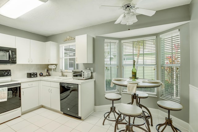 kitchen with black appliances, white cabinetry, sink, and a wealth of natural light