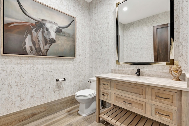 bathroom featuring wood-type flooring, vanity, and toilet