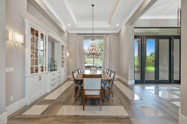 tiled dining space featuring a chandelier, french doors, crown molding, and a tray ceiling