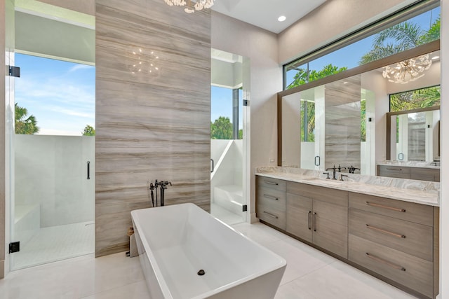 bathroom with a notable chandelier, vanity, separate shower and tub, and tile patterned flooring