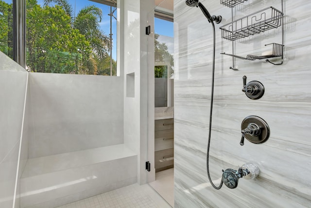 bathroom with tiled shower and tile patterned flooring