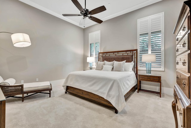 carpeted bedroom featuring ceiling fan and crown molding