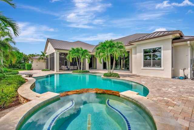 view of swimming pool with an in ground hot tub, a patio area, and a sunroom