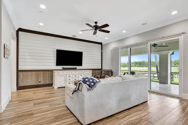 living room featuring crown molding, ceiling fan, and wooden walls