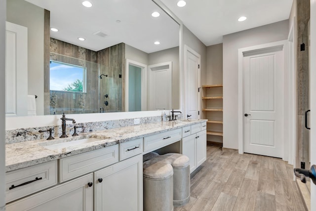 bathroom with vanity, wood-type flooring, and a shower with shower door