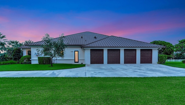 view of front facade with a yard and a garage