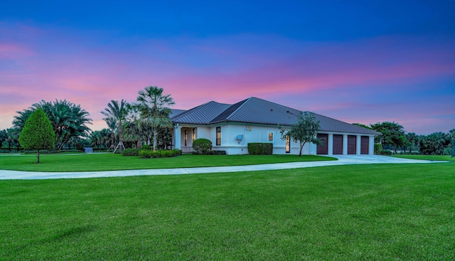 view of front of home with a yard and a garage