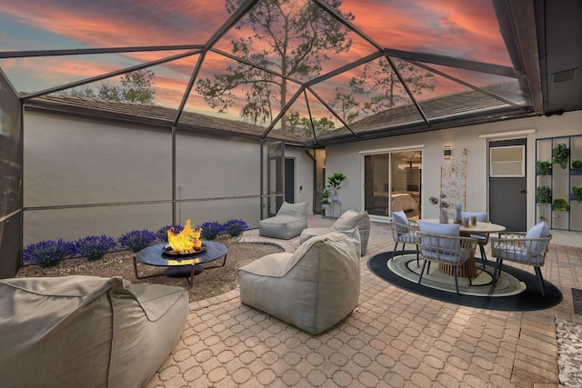 patio terrace at dusk with glass enclosure and a fire pit