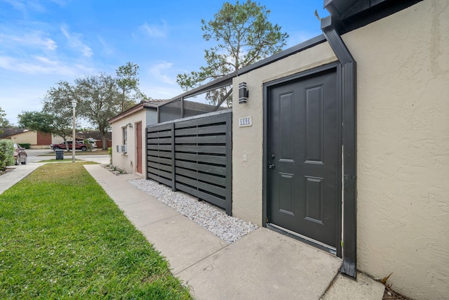 property entrance with a lawn