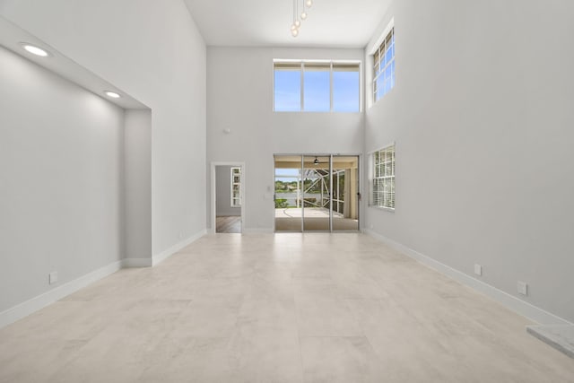 unfurnished living room with a towering ceiling