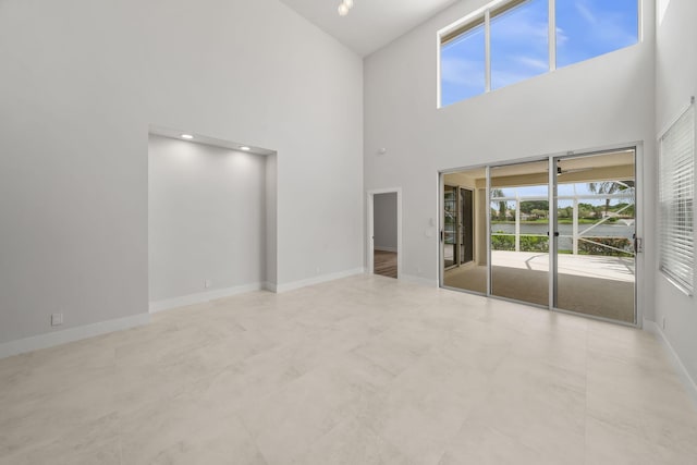 unfurnished living room featuring a high ceiling