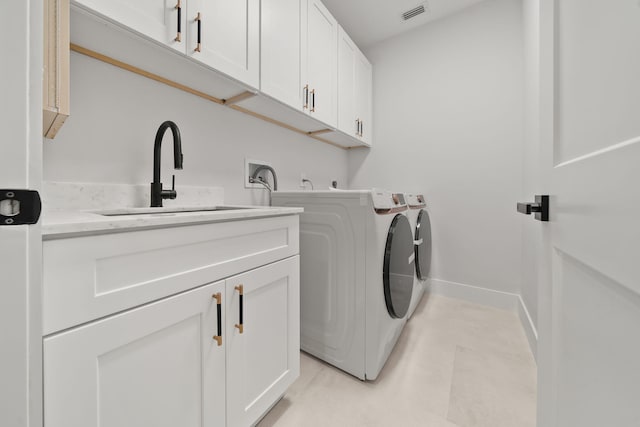 laundry room featuring cabinets, washer and dryer, and sink