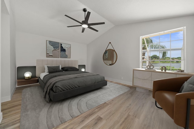 bedroom featuring ceiling fan, light hardwood / wood-style floors, and vaulted ceiling