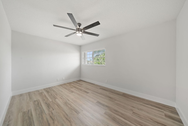 spare room featuring ceiling fan, light wood-type flooring, and a textured ceiling