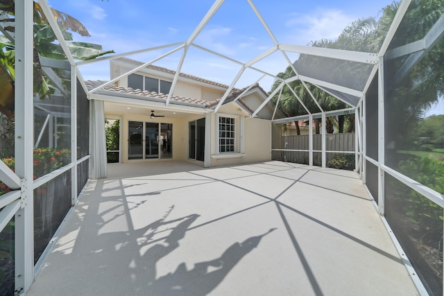 unfurnished sunroom with ceiling fan and vaulted ceiling