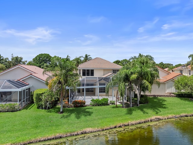 rear view of house featuring a lawn, glass enclosure, a water view, and a patio