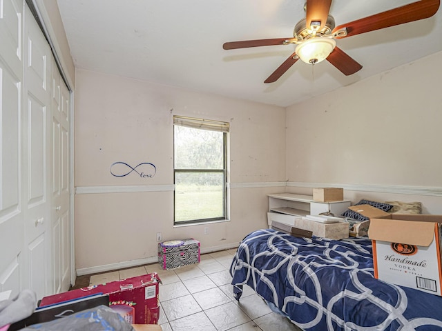 bedroom featuring ceiling fan, light tile patterned flooring, and a closet