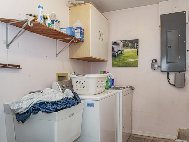 laundry room featuring washing machine and clothes dryer, electric panel, and cabinets