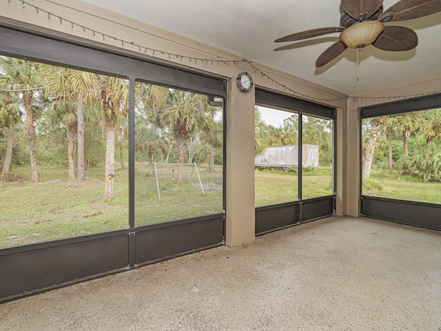 unfurnished sunroom featuring ceiling fan