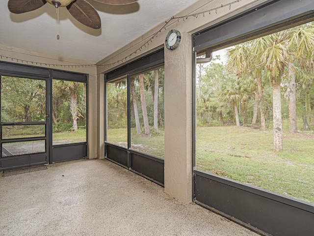 unfurnished sunroom with ceiling fan