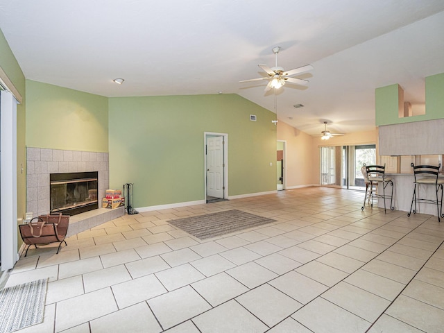 tiled living room with a fireplace, ceiling fan, and lofted ceiling