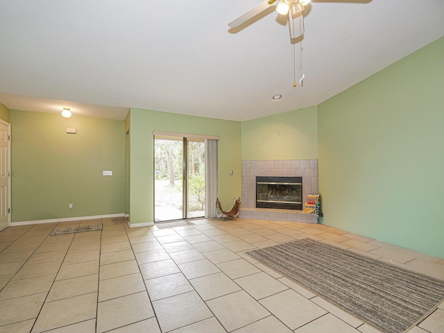 unfurnished living room featuring a tile fireplace, ceiling fan, and light tile patterned floors