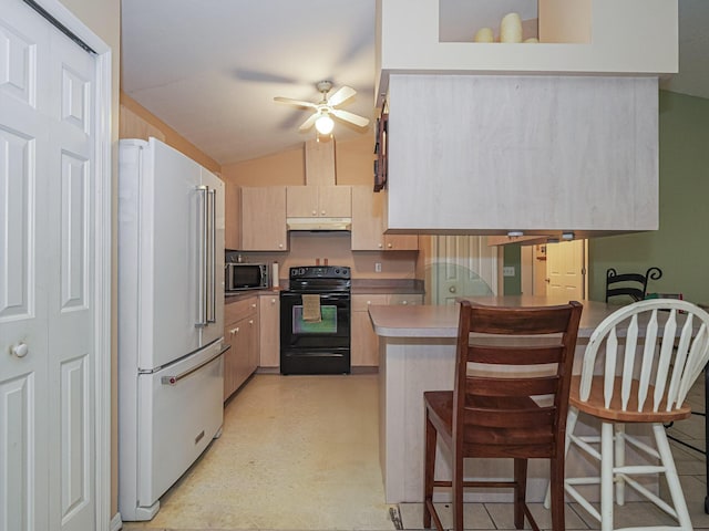 kitchen with a breakfast bar, vaulted ceiling, high end white refrigerator, and black / electric stove