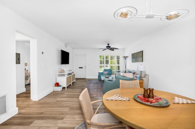 dining room featuring ceiling fan, electric panel, and light hardwood / wood-style flooring