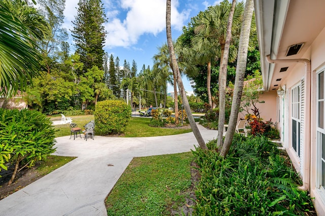 view of home's community featuring a lawn and a patio area