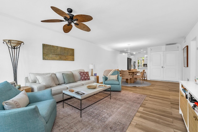 living room featuring ceiling fan and light hardwood / wood-style floors