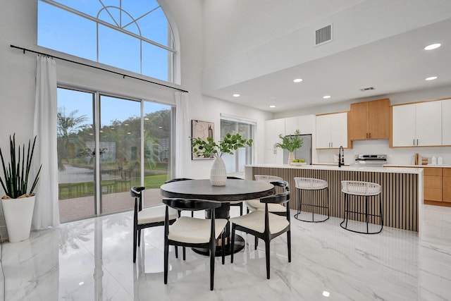 dining room featuring sink and a high ceiling