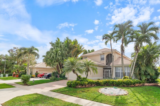 mediterranean / spanish house with a garage and a front yard