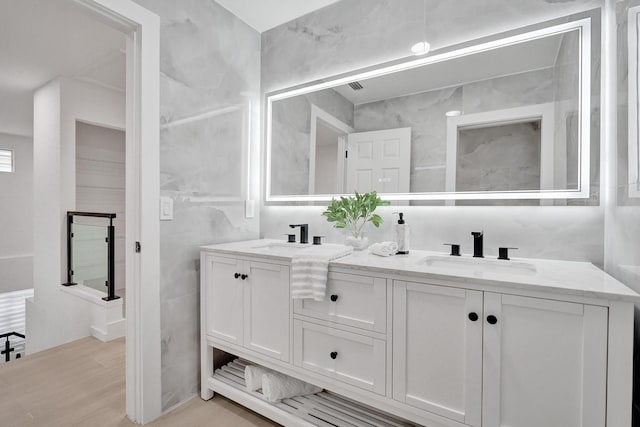 bathroom featuring hardwood / wood-style flooring, vanity, and tile walls