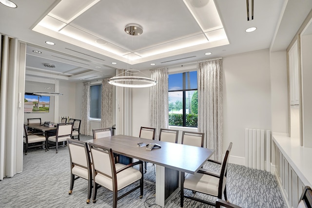 dining space featuring light carpet, a raised ceiling, and a notable chandelier