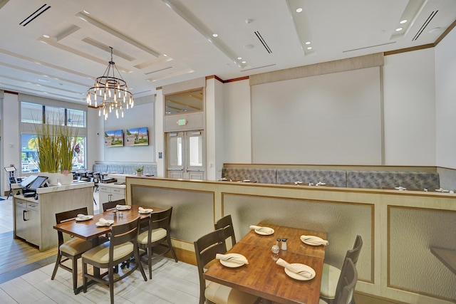 dining room with light hardwood / wood-style flooring and a notable chandelier