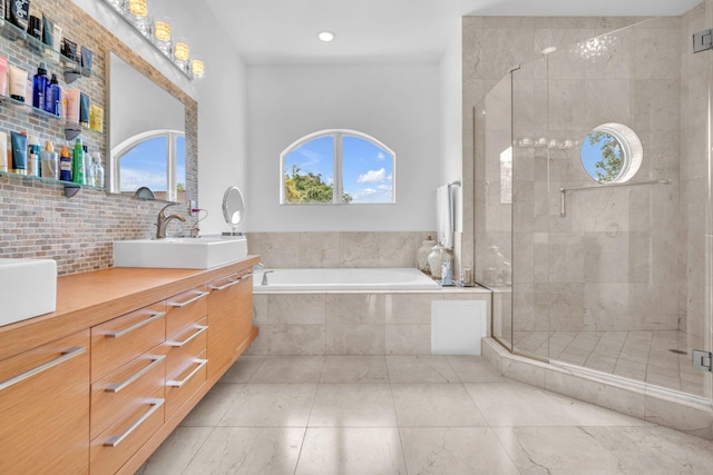 bathroom with a wealth of natural light, vanity, and independent shower and bath