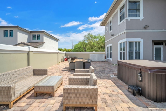 view of patio with outdoor lounge area and a hot tub