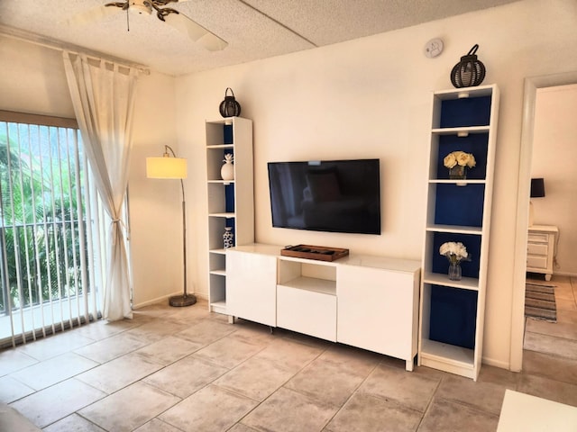 unfurnished living room with ceiling fan, light tile patterned flooring, and a textured ceiling